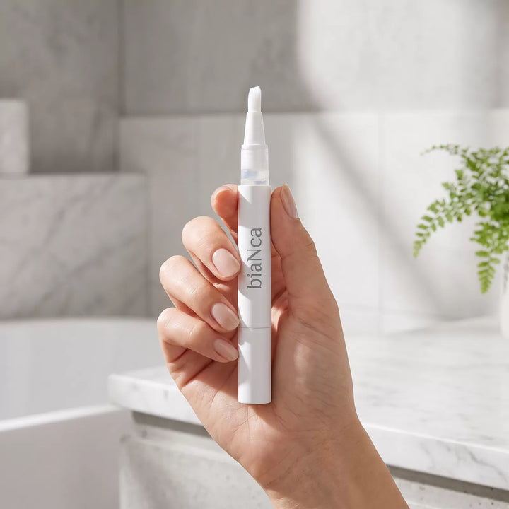 Applying whitening gel with a Bianca Bright pen to treat yellowing teeth