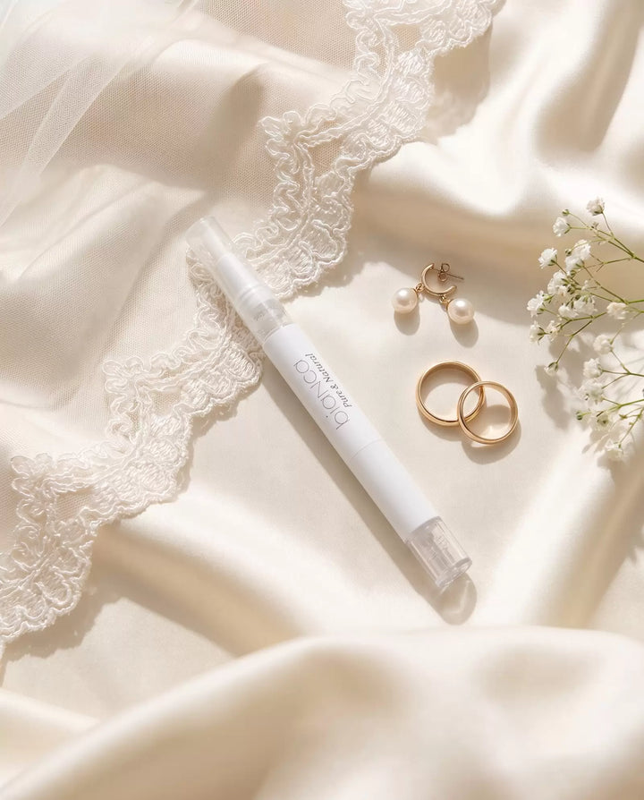 Bianca Bright whitening pen in a bridal flat lay with veil, pearls and wedding bands