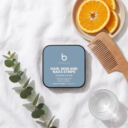 Bianca Hair, Skin and Nails Strips tin on white linen with orange slices and a wooden comb