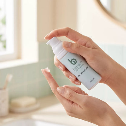 Hand dispensing Bianca Max Whitening Gel onto a fingertip at a bright bathroom vanity