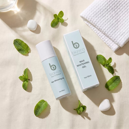 Bianca Pure & Natural Max Whitening Gel bottle and box on cream linen with fresh mint leaves