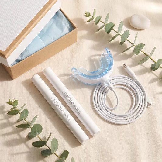Bianca Bright Smile Box contents with two whitening pens, LED tray and gift box on cream linen